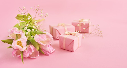 Valentines day background with pink tulips and gift box over pink background. Space for text