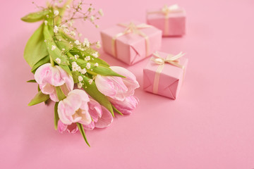 Valentines day background with pink tulips and gift box over pink background. Space for text