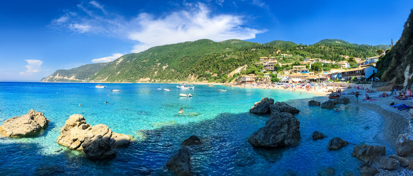 Beautiful panorama over Agios Nikitas coastline and beach with people enjoying summer holiday in Lefkada island
