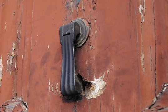 Bater &aacute; porta batedor fixado numa porta de madeira vermelha muito antiga