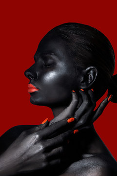  girl with black skin and red lips and nails on a red background