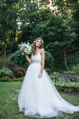 Fototapeta na wymiar Full length side view of one beautiful sensual young blonde bride in long white wedding dress
