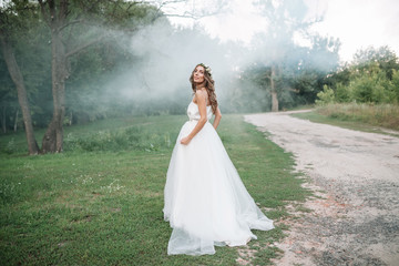 Full length side view of one beautiful sensual young blonde bride in long white wedding dress