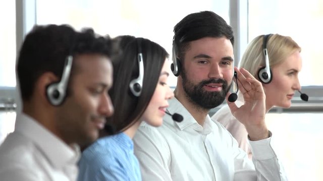 White young bearded man call center operator smiling. Tech support operator turning his head. Agree and nodding head.