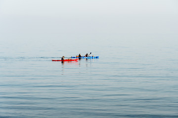 Organized group of people in kayaks floating in the sea