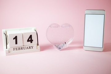  Smartphone with blank screen and wooden calendar with heart. Love and valentine's day concept.