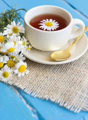 cup of herbal chamomile tea with fresh daisy flowers on wooden background. doctor treatment and prevention of immune concept, medicine - folk, alternative, complementary, traditional medicine 