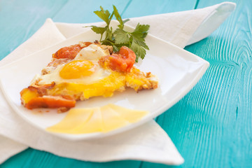 Scrambled eggs fried with tomatoes in white plate. Cheese cut into slices on the plate.