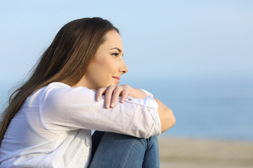 Relaxed woman thinking looking away on the beach