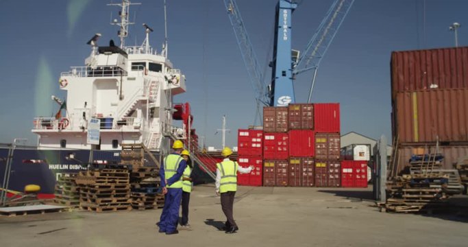 Portrait of a dock worker standing at the harbor amidst shipping industry activity. Shot on RED Epic.