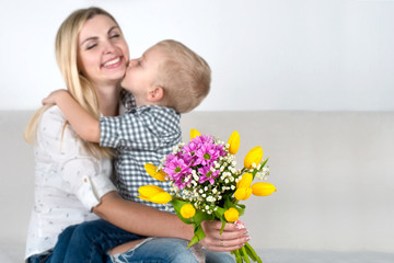 Son gives his beloved mother a beautiful bouquet of tulips.The concept of the celebration,women's day.	