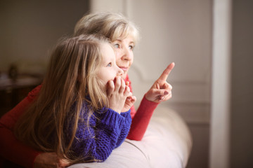 Grandmother showing something to her granddaughter
