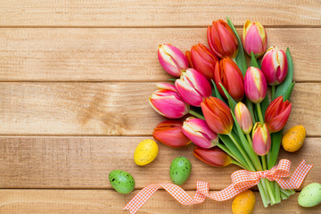 Spring easter tulips in bucket on wooden vintage background.