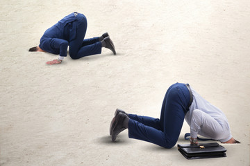 Businessman hiding his head in sand escaping from problems