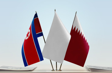 Flags of North Korea and Qatar with a white flag in the middle