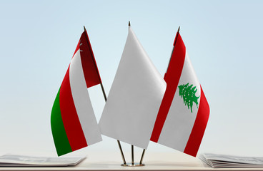 Flags of Oman and Lebanon with a white flag in the middle