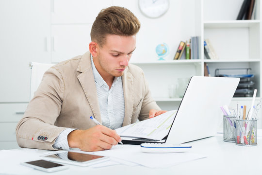Man working with documents and laptop