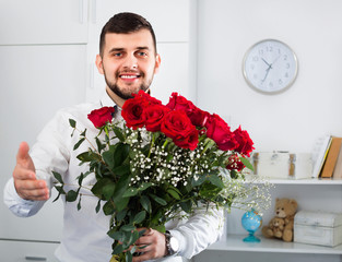 Young man ready to present flowers to woman