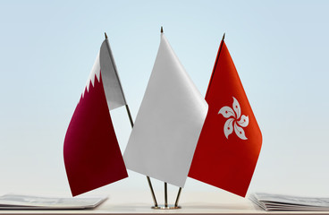 Flags of Qatar and Hong Kong with a white flag in the middle