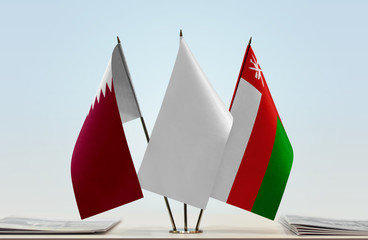 Flags of Qatar and Oman with a white flag in the middle