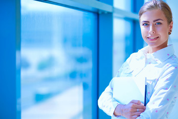 Business woman standing in foreground in office . Business woman