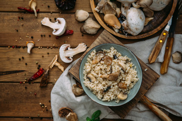 Risotto with mushrooms on an old wooden background. Rustic style.