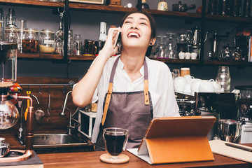 Barista woman using digital tablet compute in coffee shop counter bar