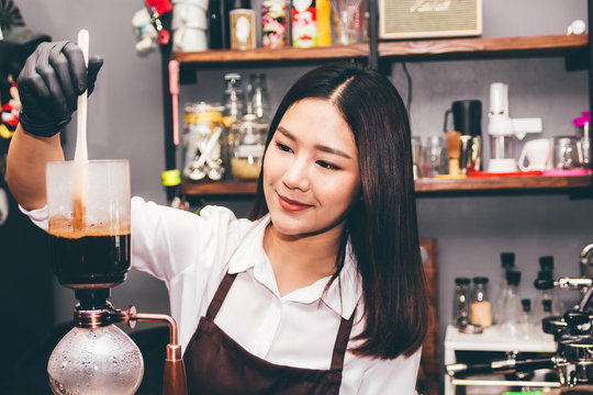 Women Barista making coffee on syphon coffee maker in the cafe