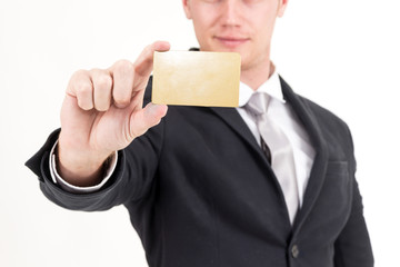 Businessman holding a blank gold business card in his hand isolated on white background
