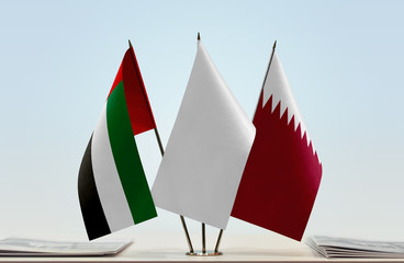 Flags of UAE and Qatar with a white flag in the middle