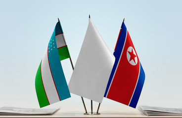 Flags of Uzbekistan and North Korea with a white flag in the middle