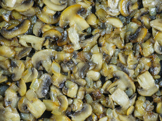 Background of finely cut fried mushrooms with onions in olive oil.