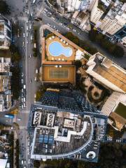 Drone view of building with pool and tennis court