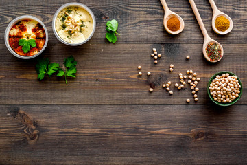 Cook chickpeas. Make hummus. Bowls with grains and ready meal near spices on dark wooden background top view copy space