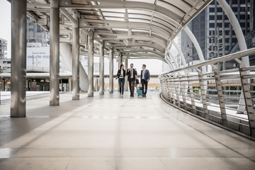 Team of business colleagues meeting while walking in a modern city to go travelling. Business travel concept.
