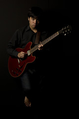 Obraz na płótnie Canvas asian young musician playing guitar