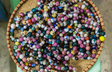 basket of ceramic beads in many colors and designs strung in bracelets 