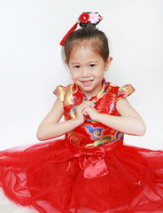 Little Asian girl with Congratulation gesture isolated on white background. Happy chinese new year.