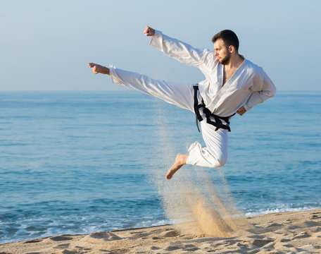 Man demonstrates kung-fu poses at seaside
