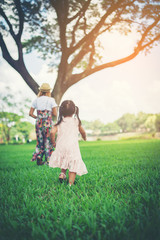 Fototapeta premium Mother and daughter playing and running in the park