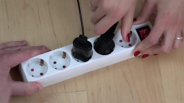 woman and man hands turn off electricity extension switch and unplug wires.