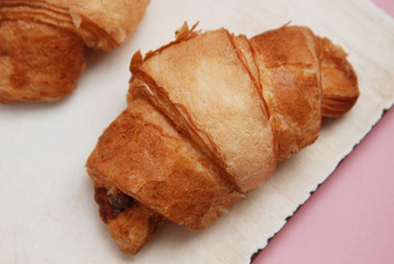 Croissant Isolated on Pink Background Over Vintage White Board. Top view. Breakfast.