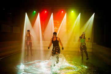 Performance on the water of a dance group against the background of club light.