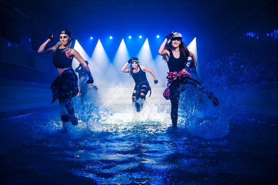 Performance on the water of a dance group against the background of club light.