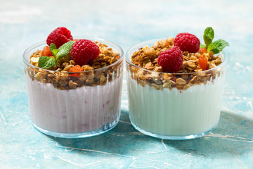 dessert with granola, raspberry, fruit and natural yoghurt on table