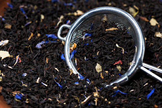 dry black tea with aromatic herbs in a strainer