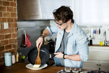Photo sur Aluminium Cuisinier Homme de race blanche cuisine dans la cuisine