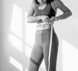 Asian woman measuring waist size