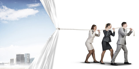 Obraz premium Young businesspeople working in collaboration and pulling white advertisement banner