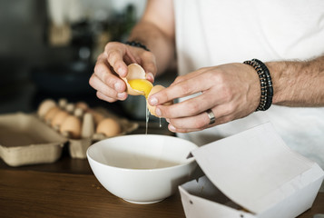Obraz na płótnie Canvas Closeup of man separating egg yolk